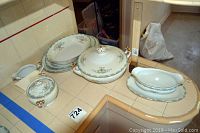 Full set of Mikado China serving pieces laid out on tiled counter including sugar bowl with lid, creamer, gravy boat with underplate, casserole dish with lid, and three serving dishes.