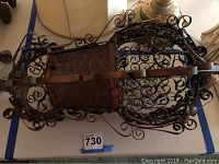 Top-down view of the vintage metal and glass chandelier showing the intricate scrollwork and metal frame detail