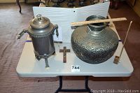 Large vintage metal vase and 3-piece metal percolator side by side on folding table with measuring ruler on vase