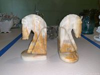 Close side view of alabaster horse head bookends showing beige and light brown streaks.