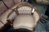 Front view of the vintage Victorian settee showing the carved wood frame, silk upholstery with tufted backrest and sides, button detailing, and nailhead trim.
