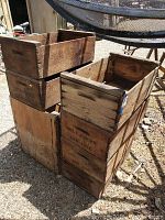 Side-view stacked wooden fruit boxes showing aged wood and stamped distributor text.