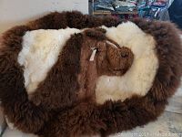The full round llama alpaca rug wall hanging showing brown and white fur with llama shape