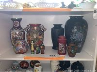 Shelf with assortment of vintage Japanese vases and three small figurines