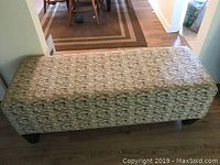 Seating bench showing top, upholstery and legs.