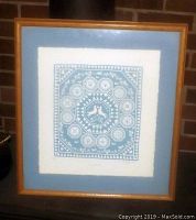Framed full view showing the art print, matting and wood frame against a brick wall background.