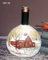 Full front view of vintage green glass bottle with hand-painted winter water mill on flattened round body.