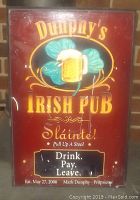 Full view of Dunphy's Irish Pub plaque showing front design and text with scratches visible