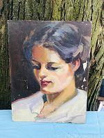 Front view of the antique oil painting on board showing the portrait of a woman with dark hair and white garment. The painting has aged wear and minor paint loss.
