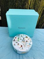 Photo showing Tiffany blue box behind the round porcelain trinket box with world map illustrations on lid.
