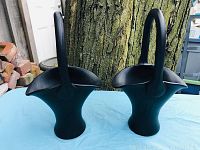 Pair of black satin glass baskets with handles and ruffled openings, positioned side by side against a tree background.