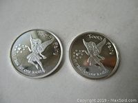 Front side of both silver Tooth Fairy coins showing fairy design and trade text.