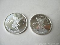 Two silver Tooth Fairy coins front side showing fairy design and inscription.