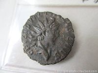 Obverse side of the ancient coin showing the right-facing bust of Tetricus II Caesar with radiate crown.