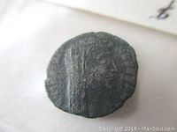 Obverse of ancient Roman bronze coin showing veiled head of Emperor Constantine I facing right.