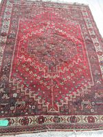 Full view of Persian Shiraz area rug showing central medallion and color pattern in red and dark brown with geometric borders.