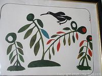Close-up of wood block print showing stylized bird and colorful plants in a white background with rounded black border, framed in wood with glass.
