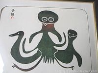 Close-up of the framed wood block print artwork showing an octopus, seal, and bird in black and muted red tones, with a signature in syllabics.