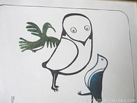 Close-up of bird woodblock print artwork showing black and white bird figures with green and blue accent colors.