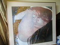 Front view of framed Gustav Klimt art print showing reclining nude woman with gold accents