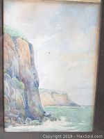 Frontal view of painting showing cliffs and sea within frame