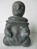 Front view of the Inuit stone carving showing detailed facial features and hands.