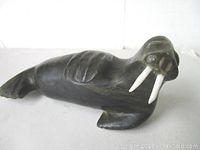 Front angled view of vintage Inuit stone walrus sculpture showing detailed flippers, tusks, and body shape.