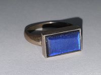 Photo showing rectangular deep royal blue stone in sterling silver ring, lit to reveal stone texture and silver finish.