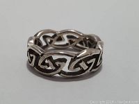 Close-up photo of a sterling silver ring with detailed Celtic knot design.