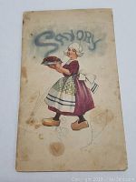Front cover of Savory Prize Recipe Book showing a woman in a dress and apron carrying a cooked dish.