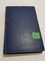 Blue hardcover book with minor wear and sticker on front cover.