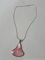 Full view of sterling silver necklace with bell-shaped pink paua shell pendant.