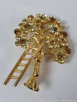 Front view of the gold toned tree brooch showing details of the ladder and rhinestone decorations.