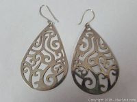Pair of large petal or teardrop-shaped sterling silver earrings with detailed swirl cut-out patterns, hook closures visible, front view showing design detail and condition.