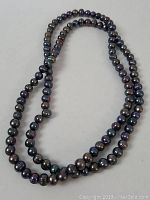 Full view of the 32 inch freshwater pearl necklace laid out showing the strand and multicolored pearls.