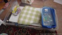Overall view of plastic bins containing loose Lego pieces and chair mat on tiled floor