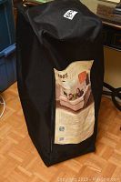 Black carrying bag standing upright with the product label showing an image of the bed and general product information