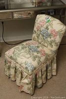 Full view of the floral upholstered skirted bedroom chair showing the backrest and seat.