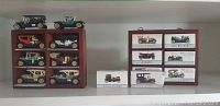 Front view of two wooden displays containing 12 miniature antique cars and 4 card boxes with car images and names.
