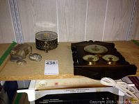 Wide view of the weather station on wooden shelf next to soapstone frogs and bath bead container