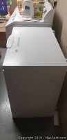 Side view of the white Kenmore chest freezer with boxes on top.