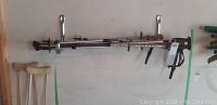 Metal expandable walking sticks with adjustable height and interchangeable tips mounted horizontally on a wall rack.
