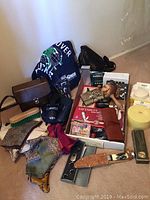 Overview photo showing all items in the lot including knife, wallets, maraca, small boxes, and a cloth item.