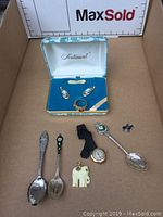 Overview of all items including earrings, ring, spoons, watch, and miscellaneous jewelry pieces arranged in a box and on surface.