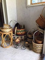 Photo showing natural wicker stool 15 inches tall with assorted woven baskets in multiple designs and sizes stacked and grouped around it.