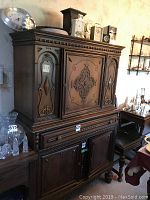 Full view of the vintage wooden hutch showing its ornate carved front panels, top drawer, and double cabinet doors below.