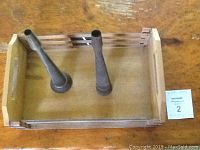 Wooden tray with two metal funnels placed inside it, showing size and overall condition.