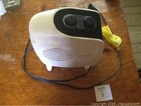 Front and side view of Honeywell small white space heater showing two control knobs and vents on front panel.