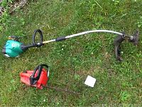 Full view of the Weedeater FeatherLite 25cc weed trimmer showing green engine housing, curved shaft, and cutting head with guard on grass