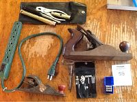 Photo showing the wood planes, motorcycle tool set pouch with various tools, and green electrical power strip